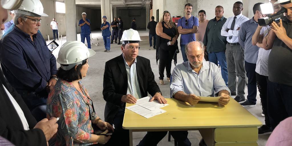 A então secretária de Saúde, Tânia Trilha, junto ao prefeito Renato Bravo e a Aurélio Ruben Mury, representante da Fringe, durante a assinatura do contrato, em março de 2019