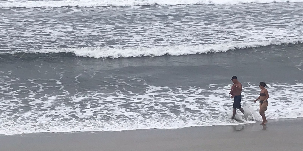 Banhistas aproveitam o mar em Cabo Frio, mesmo com o tempo nublado 