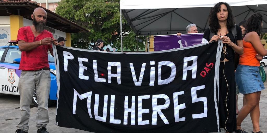 Manifestantes seguram cartaz de protesto