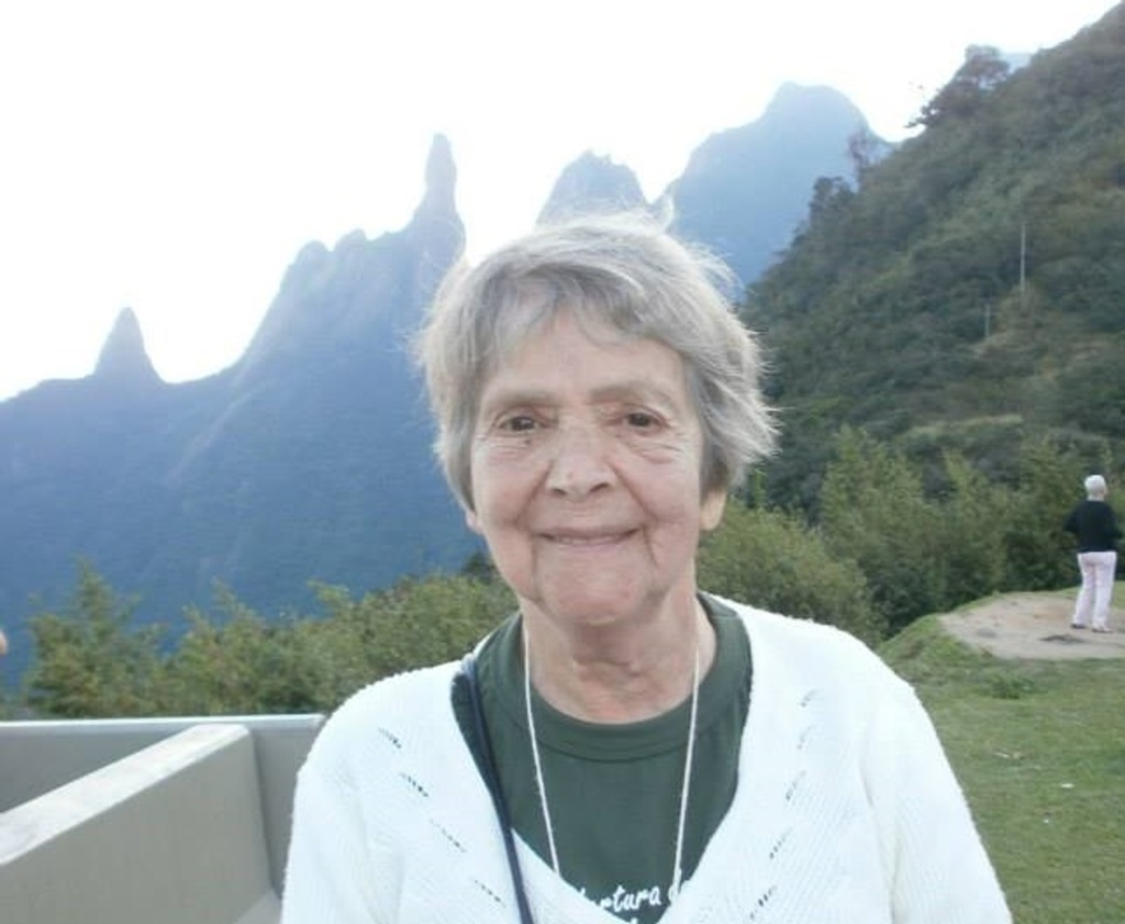 Lilia na atualidade com a pedra do Dedo de Deus ao fundo, em Teresópolis