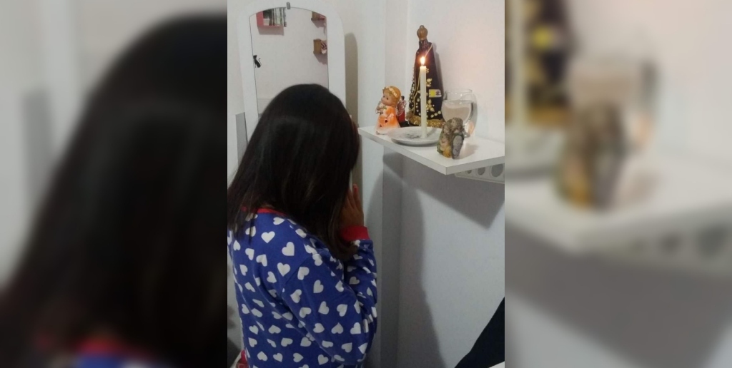 Ana Júlia rezando para Nossa Senhora Aparecida