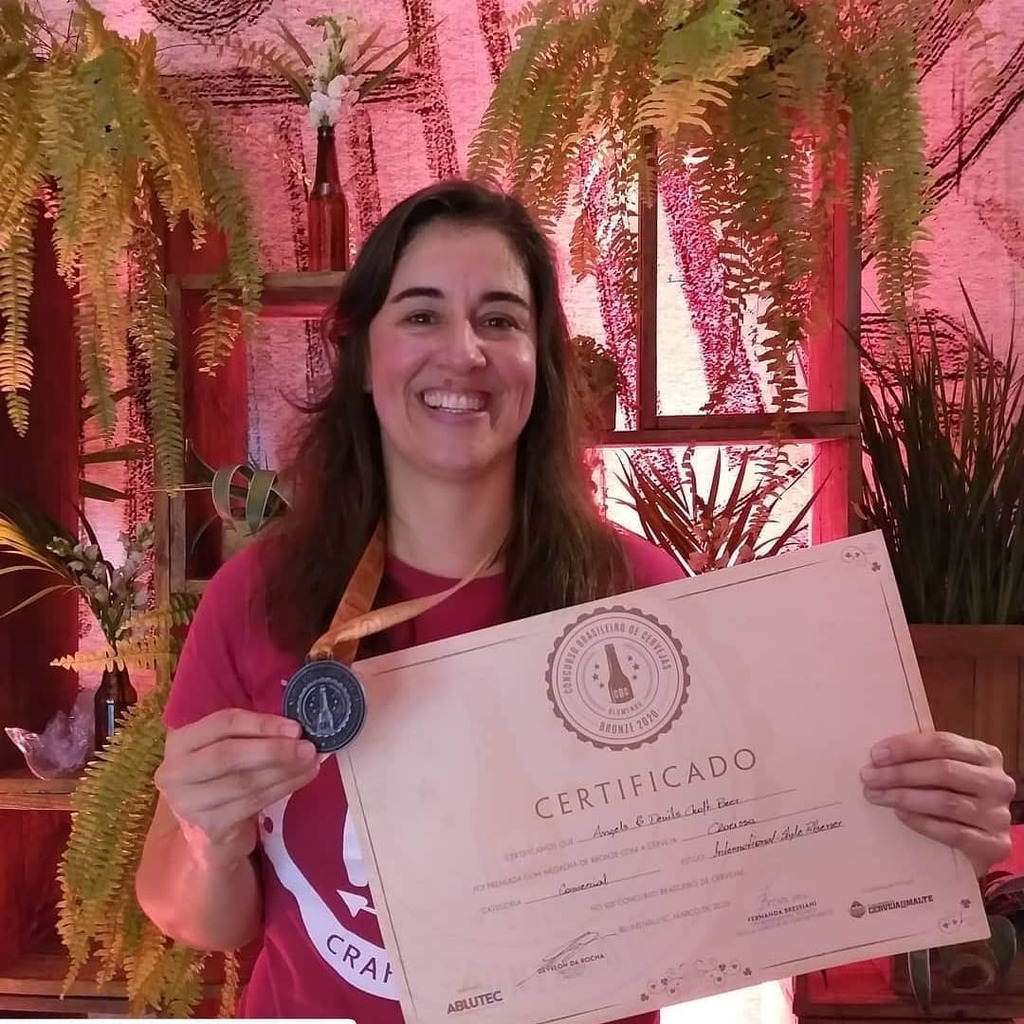 Mônica Mendonça segura o certificado e a medalha de bronze em razão da cerveja “Clarissa”
