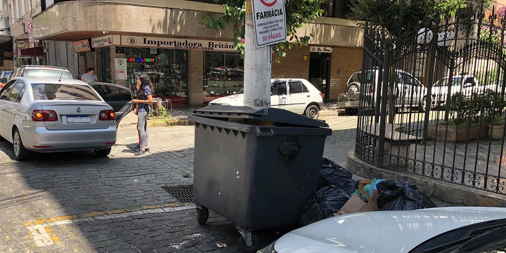 Em Nova Friburgo, lixo ocupa calçada e caçamba ocupa vaga de farmácia