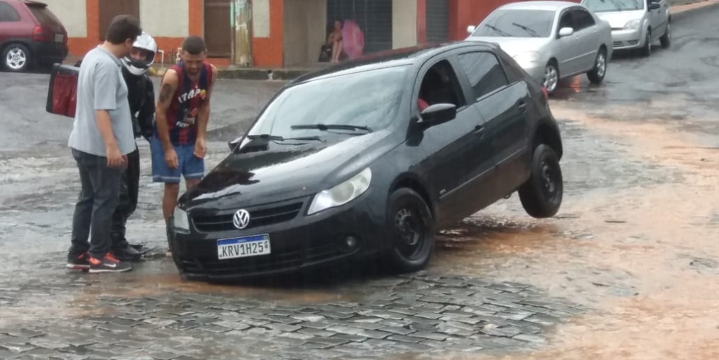 Carro fica com a roda dianteira presa em buraco na rua Albertino Quadro Gama, em Conselheiro Paulino