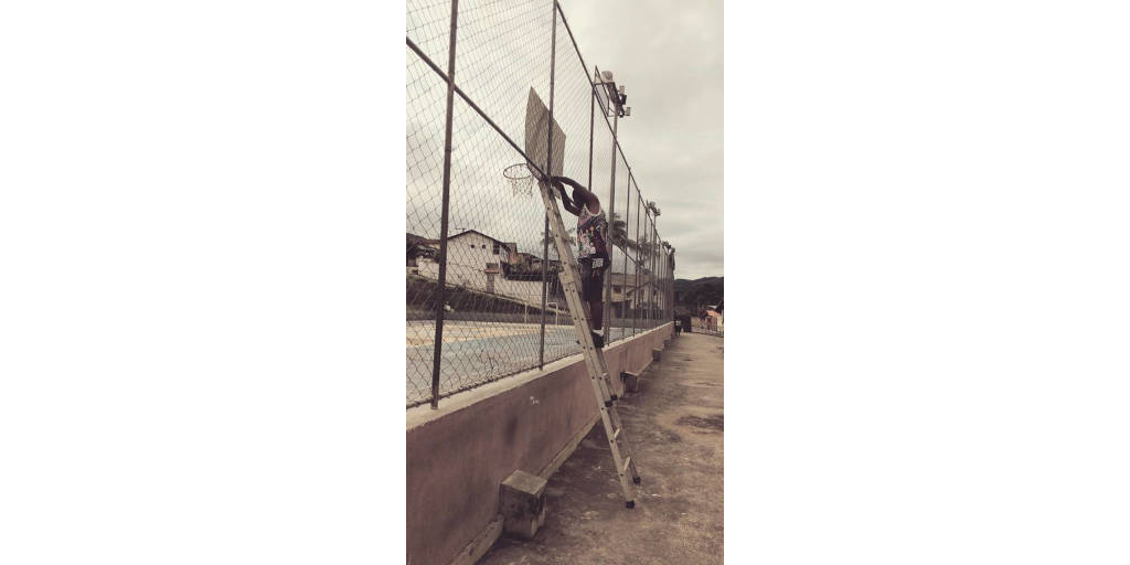 Voluntário durante conserto de grade da quadra poliesportiva 